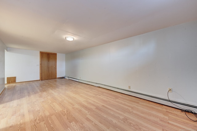 spare room featuring a baseboard radiator and light hardwood / wood-style flooring