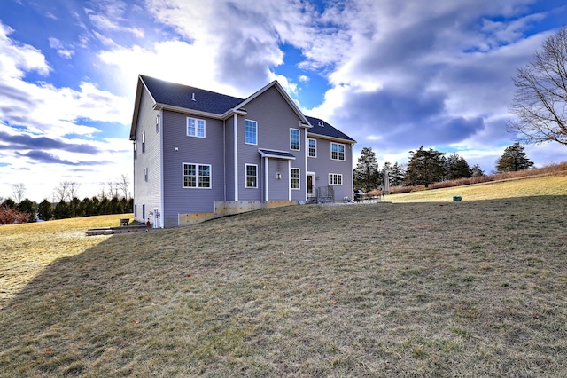 rear view of property featuring a yard