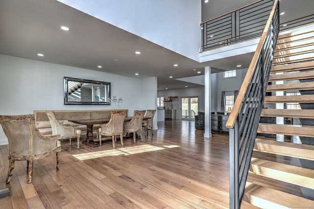 dining area with hardwood / wood-style floors and a high ceiling