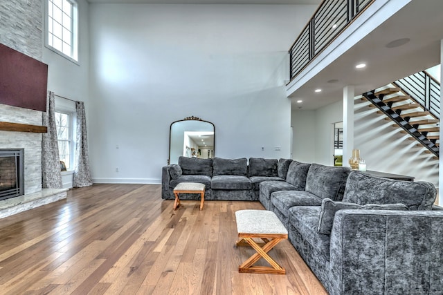 living room with a towering ceiling, a fireplace, and a healthy amount of sunlight