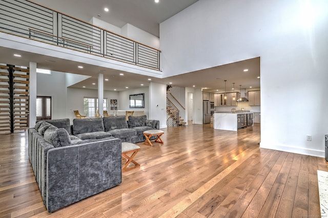 living room with a high ceiling and light hardwood / wood-style floors