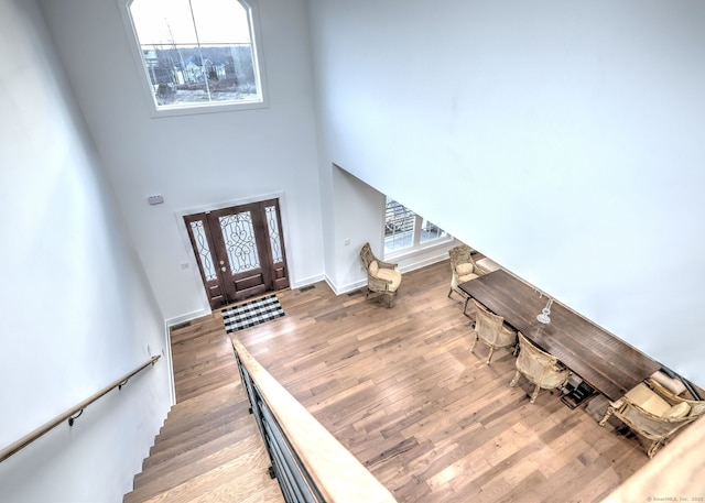 entryway featuring a towering ceiling and light hardwood / wood-style floors