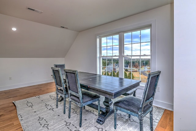 dining area with wood-type flooring and lofted ceiling