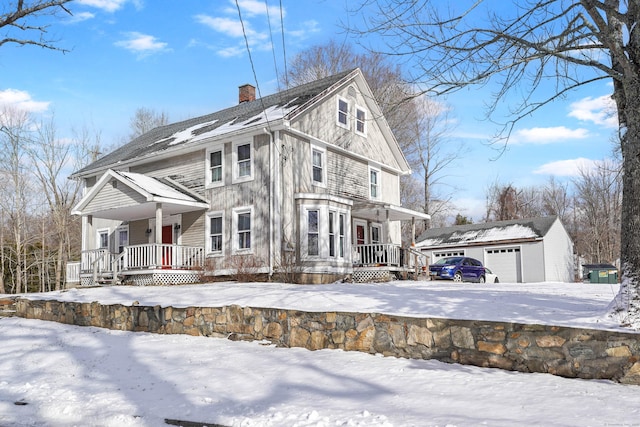 view of front of house featuring a garage, an outdoor structure, and covered porch