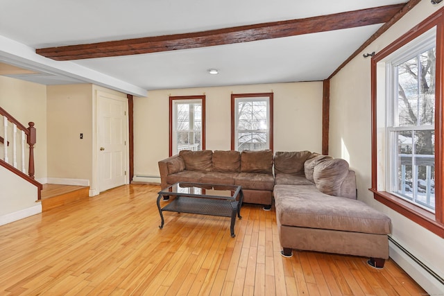 living room featuring beamed ceiling, a baseboard radiator, and light hardwood / wood-style flooring