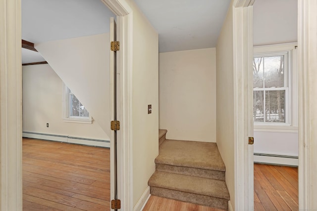 stairs with a baseboard radiator and wood-type flooring