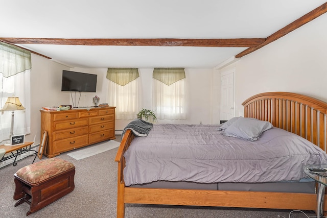 carpeted bedroom with beam ceiling