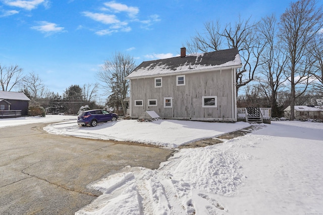 view of snow covered back of property