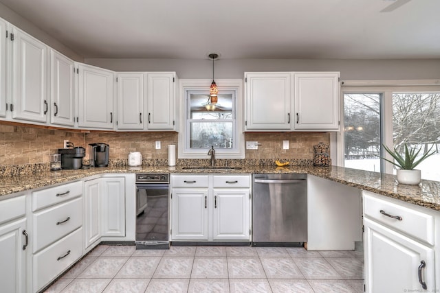 kitchen with dishwasher, white cabinetry, hanging light fixtures, sink, and dark stone counters