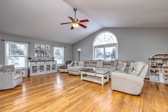 living room with light hardwood / wood-style floors, baseboard heating, lofted ceiling, and ceiling fan