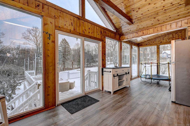 sunroom featuring wooden ceiling and lofted ceiling with skylight