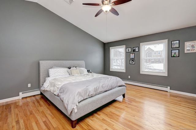 bedroom with ceiling fan, a baseboard radiator, hardwood / wood-style floors, and vaulted ceiling