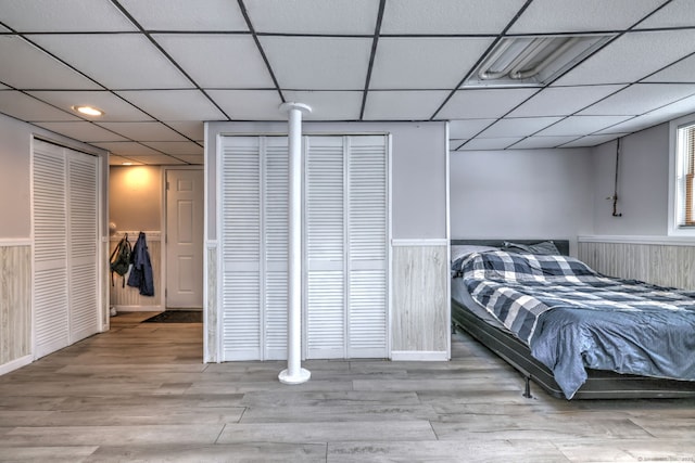 bedroom featuring a paneled ceiling and light hardwood / wood-style floors