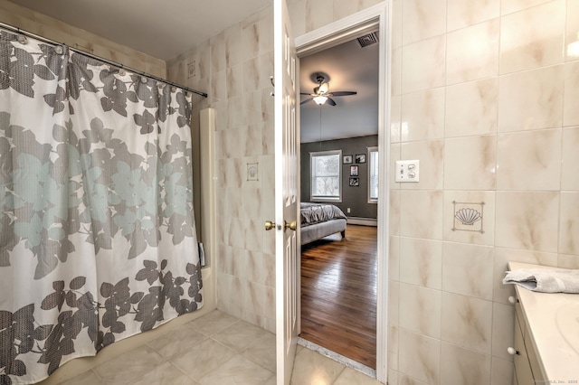 bathroom with ceiling fan, tile walls, and vanity