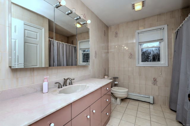 bathroom with baseboard heating, tile patterned floors, tile walls, toilet, and vanity