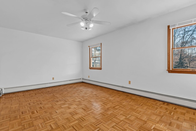 empty room with a baseboard heating unit, ceiling fan, a healthy amount of sunlight, and light parquet flooring