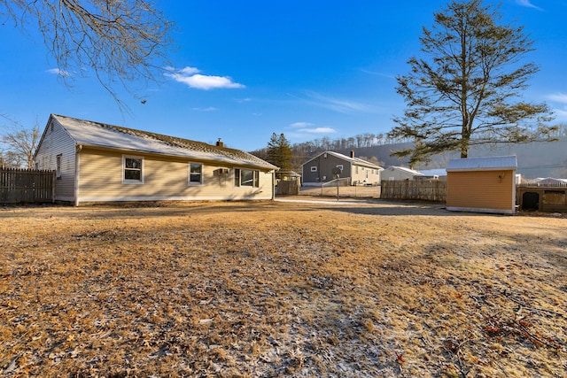 rear view of house with a storage unit