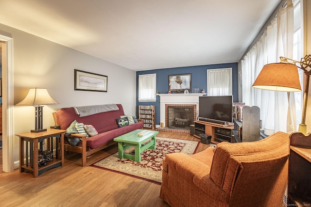 living room featuring light wood-type flooring and a fireplace