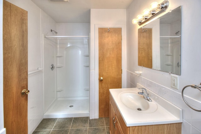 bathroom featuring walk in shower, vanity, backsplash, and tile patterned flooring