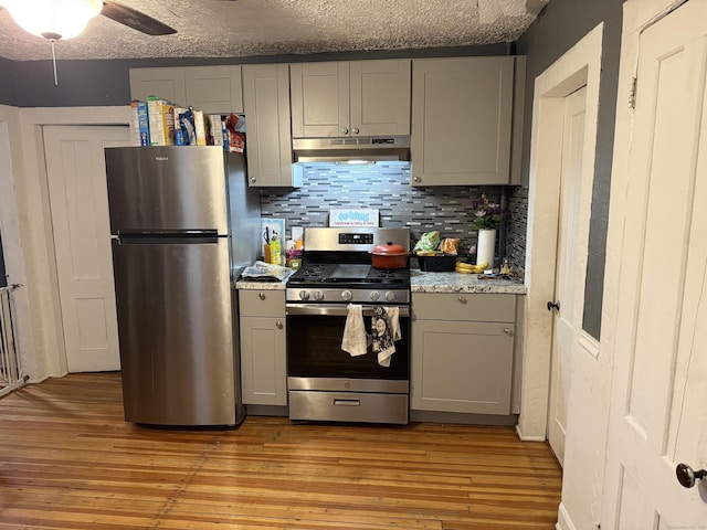 kitchen featuring appliances with stainless steel finishes, gray cabinetry, and decorative backsplash