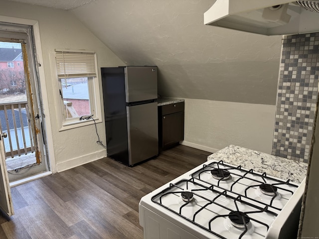 kitchen with vaulted ceiling, white gas stove, dark hardwood / wood-style flooring, and stainless steel refrigerator