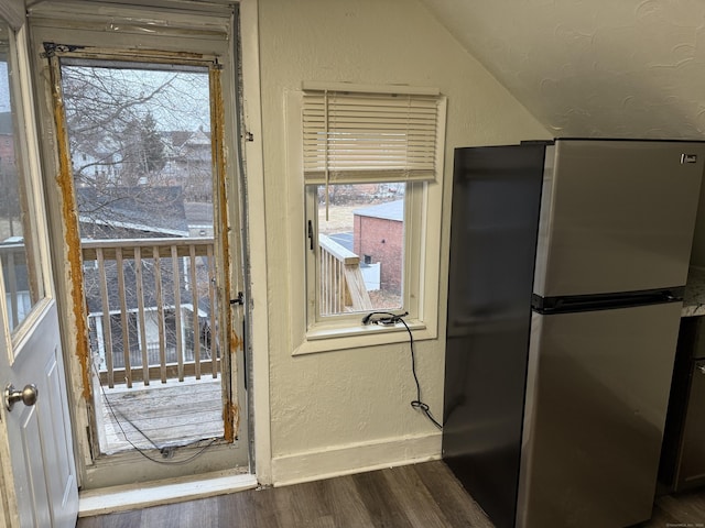 doorway to outside featuring vaulted ceiling and dark wood-type flooring