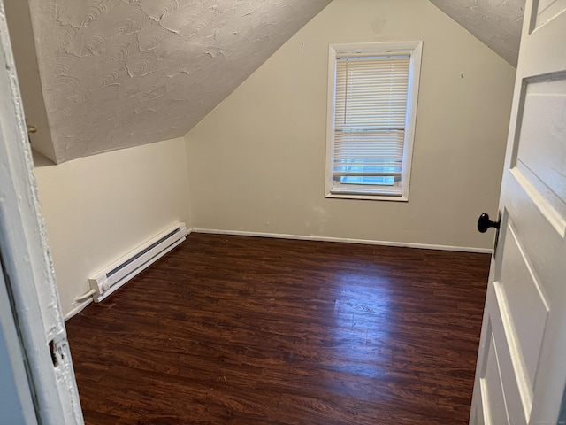 bonus room with dark wood-type flooring, a textured ceiling, a baseboard heating unit, and lofted ceiling