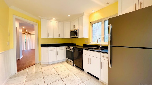 kitchen featuring ceiling fan, appliances with stainless steel finishes, sink, and white cabinetry