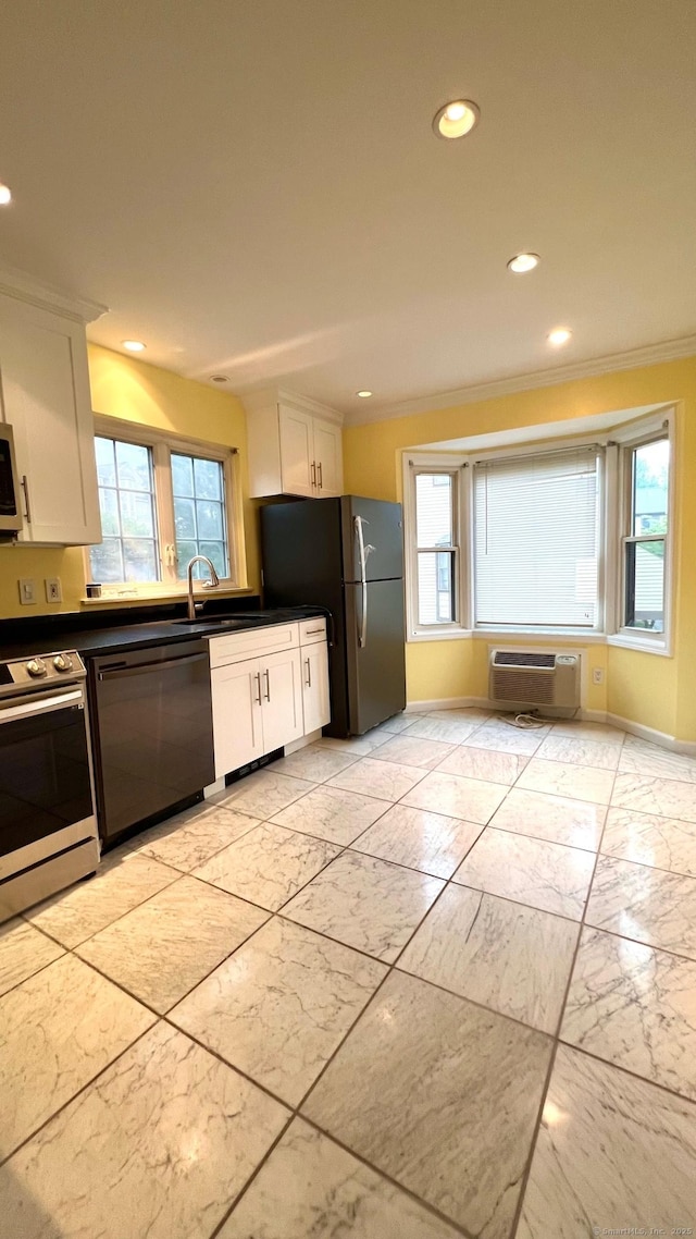 kitchen with an AC wall unit, ornamental molding, stainless steel appliances, and white cabinetry