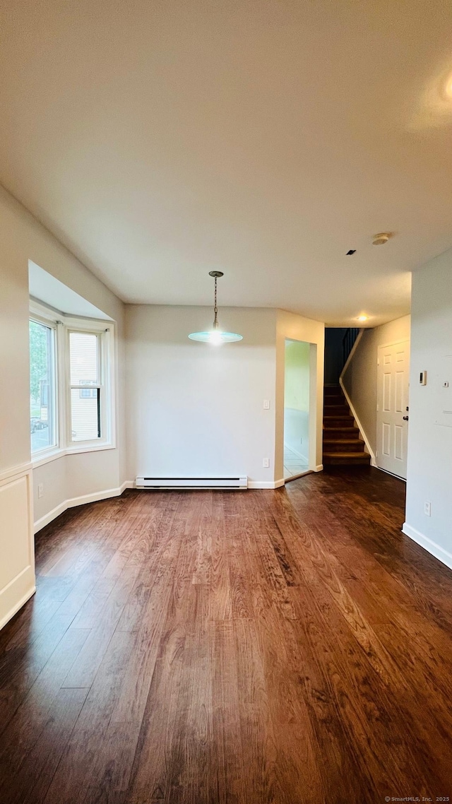 spare room featuring dark wood-type flooring and baseboard heating