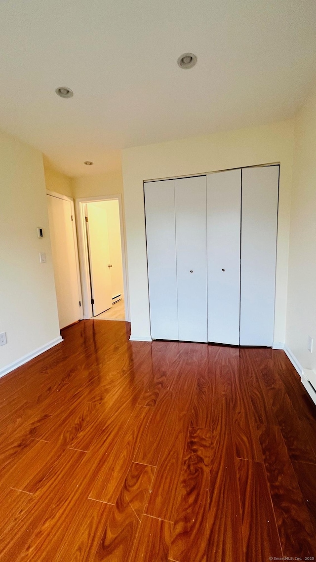 unfurnished bedroom featuring hardwood / wood-style flooring and a closet