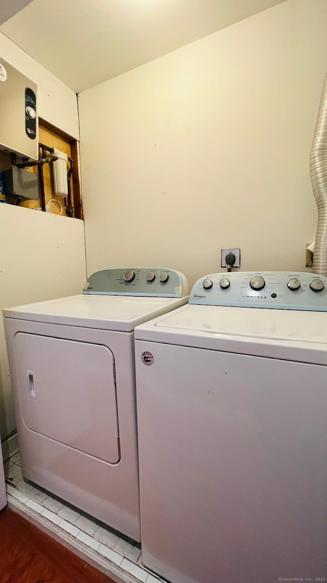 washroom with dark hardwood / wood-style flooring and washing machine and clothes dryer