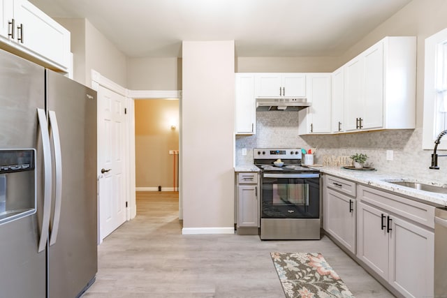 kitchen with sink, light stone counters, stainless steel appliances, and white cabinetry