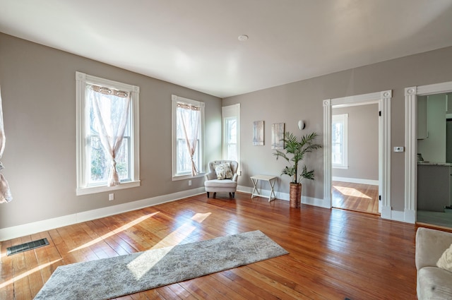 sitting room with hardwood / wood-style flooring and a healthy amount of sunlight