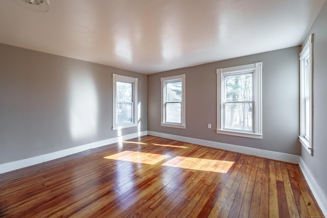 empty room featuring a healthy amount of sunlight and hardwood / wood-style floors