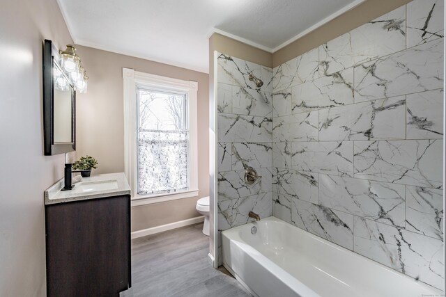 full bathroom featuring toilet, tiled shower / bath combo, hardwood / wood-style flooring, crown molding, and vanity