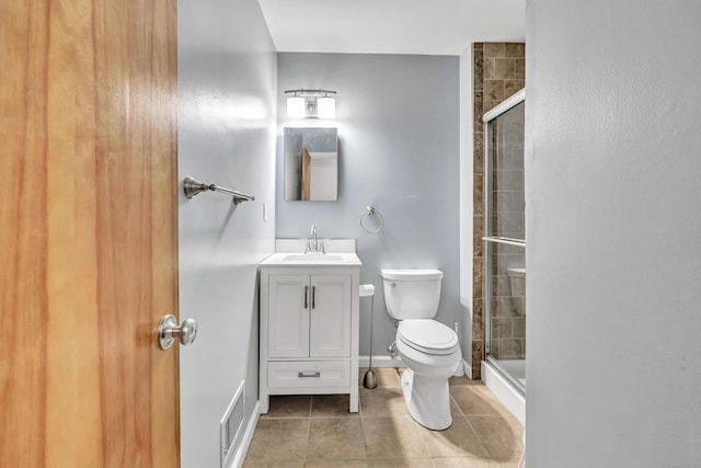 bathroom featuring toilet, tile patterned flooring, an enclosed shower, and vanity