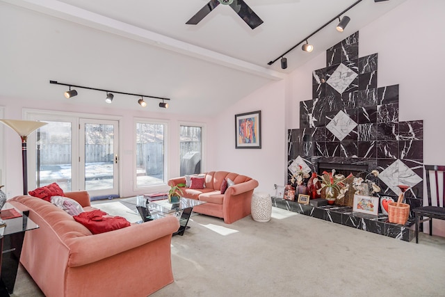 carpeted living room featuring ceiling fan, a high end fireplace, and vaulted ceiling with beams