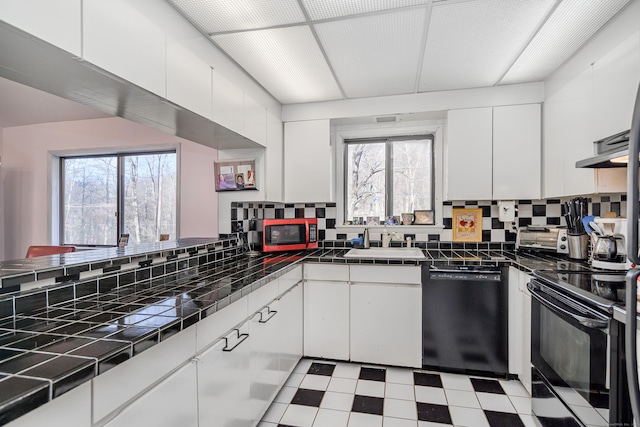 kitchen with black appliances, white cabinets, decorative backsplash, and tile countertops