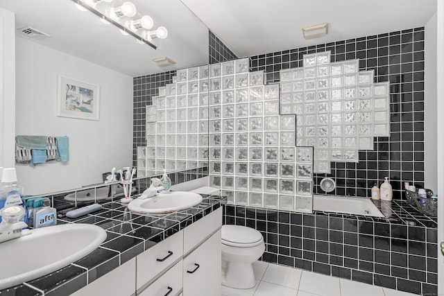 full bathroom featuring toilet, tile patterned flooring, tile walls, and vanity