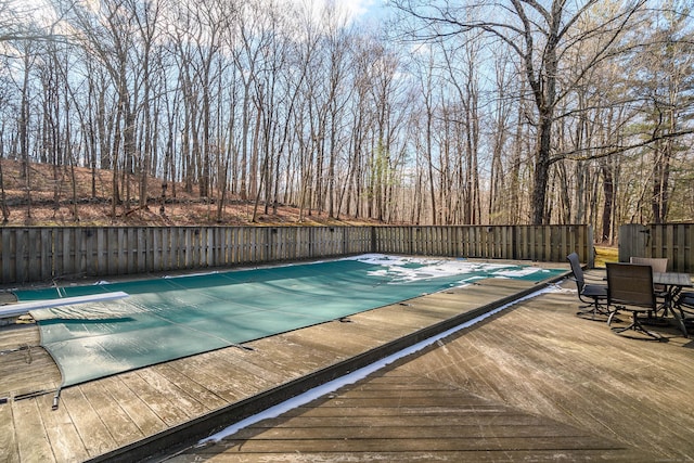 view of swimming pool featuring a wooden deck and a diving board