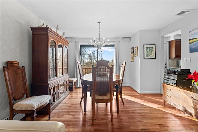 dining space featuring hardwood / wood-style flooring and a chandelier