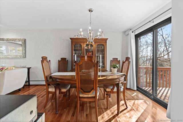 dining area featuring a baseboard radiator, hardwood / wood-style floors, and a chandelier