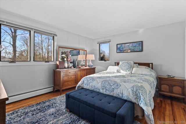 bedroom with dark hardwood / wood-style floors and baseboard heating