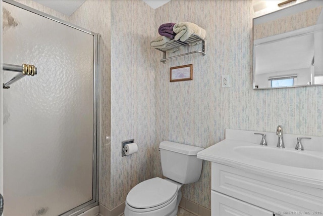 bathroom with a shower with shower door, toilet, and vanity