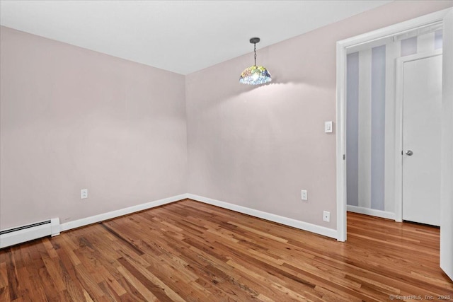 unfurnished dining area featuring baseboard heating and wood-type flooring