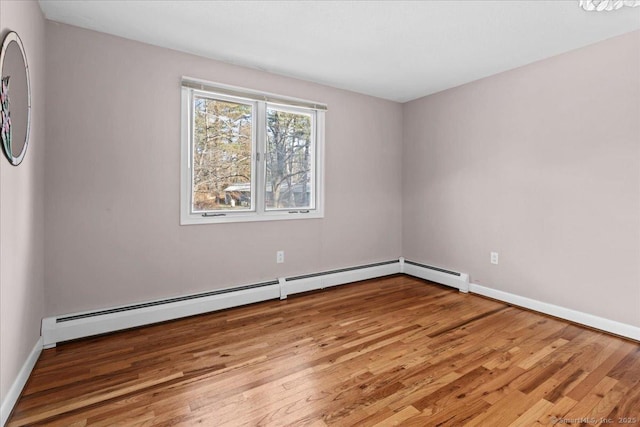 spare room featuring a baseboard radiator and light wood-type flooring