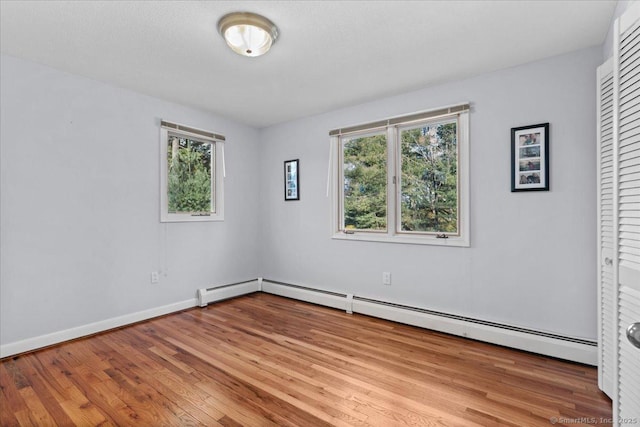 spare room featuring light wood-type flooring and baseboard heating