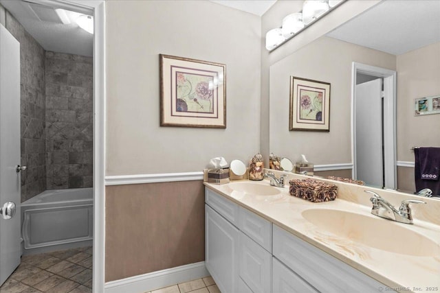 bathroom with vanity, tiled shower / bath, and tile patterned flooring