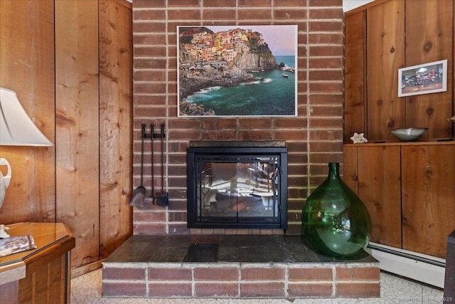 room details with a fireplace, wood walls, and a baseboard heating unit